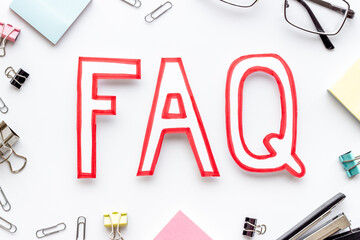 Text faq frequently asked questions on office table with stationery