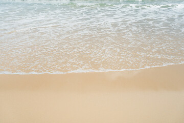 Fototapeta na wymiar Beautiful waves breaking onto sand.Top view of clear turquoise sea and foamy waves.