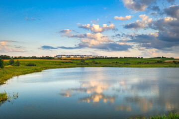 Beautiful scenery of the lake with amazing clouds before sunset, Poland