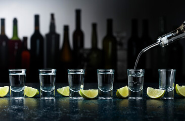 Shots of tequila with lime slices.