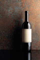 Bottle of red wine on rusty brown background.