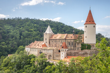 Fototapeta na wymiar medieval castle with a round tower in the valley between the hills
