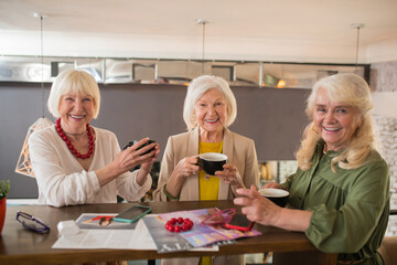 Old friends spending time together and having coffee in a cafe