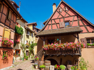 Fototapeta na wymiar Street with colorful traditional french houses in Eguisheim, France
