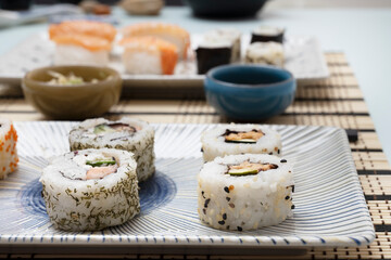 Plate with uramaki stuffed with Philadelphia cheese with salmon with dill and sesame seeds and poppy