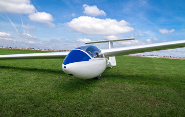 Glider airplane on a grass runway.