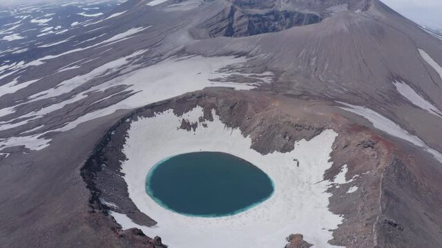 The blue lake in the crater of Gorely volcano. Kamchatka Peninsula, Russia