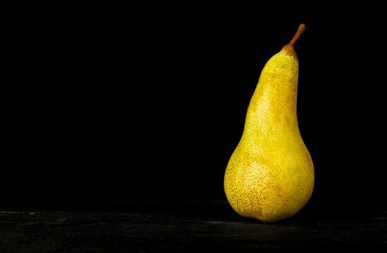 Healthy, delicious pear on a black background, with copy space.