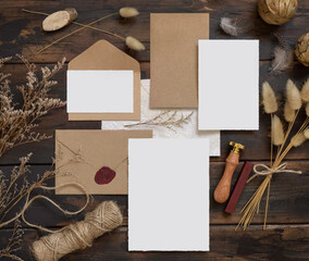 Wedding blank cards laying on a wooden table with bohemian decoration around