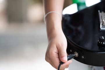 woman hand changing electric guitar settings. Tuning a timbre regulator