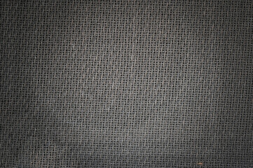 Brown and black speaker grill cloth from the vintage electric guitar amp cabinet. Background or texture.