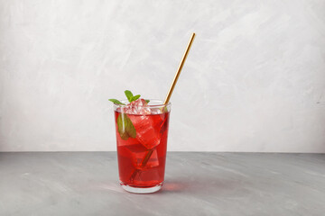Red refreshing drink with mint on grey background. Colorful summer non-alcoholic refreshing drink...