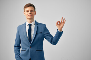 cheerful business man in suit gesturing with hand emotions posing studio