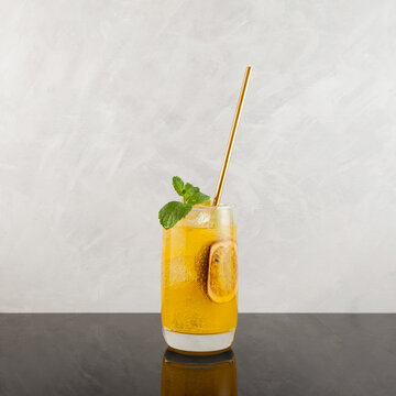 Mango passionfruit margarita cocktail with mint leaf and Lime. Tropical alcoholic drink for summer party. Grey background, copy space