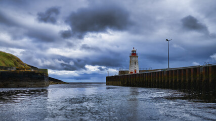 Fototapeta na wymiar Lybster, the lighthouse and the harbour in the Highlands with the Beatrice Oil Field on the horizon