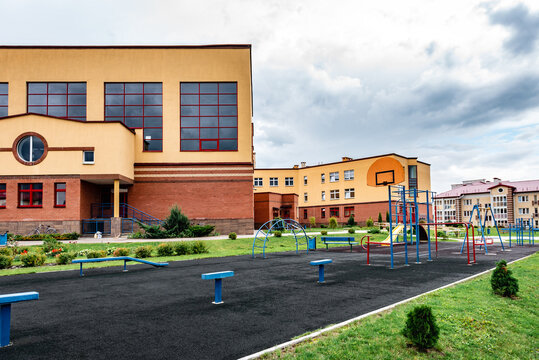 Exterior view of modern public school building with playground.