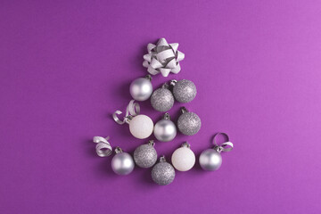 Christmas tree made of metallic baubles on purple background. Top view. Christmas and New Year concept.