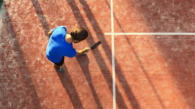Top view of a padel teacher showing where the ball has to be hit in a serve. Paddle tennis school on the outdoor court.
