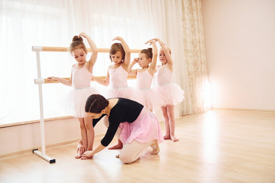 Working with coach. Little ballerinas preparing for performance by practicing dance moves