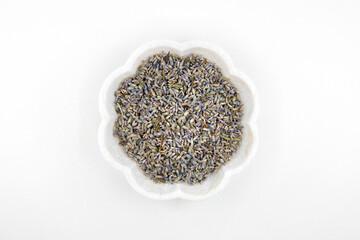 Dry or dried lavender flowers in the white bowl isolated on white background.