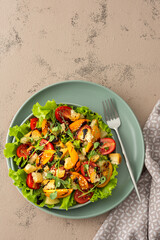 Light summer fresh salad with colorful tomatoes and croutons, lettuce and pineapple, sesame seeds and balsamic sauce