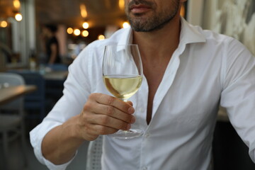 Męskie dłonie i białe wytrawne wino. - obrazy, fototapety, plakaty