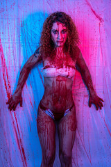 attractive slim curly-haired girl with a body full of blood leaning against a wall with plastics covered with blood splatter in purple and pink lighting