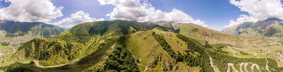 Aerial panorama of Gergeti Trinity Church (Tsminda Sameba) in Kazbegi, Georgia. The Church near the village of Gergeti, under Mount Kazbegi in summer