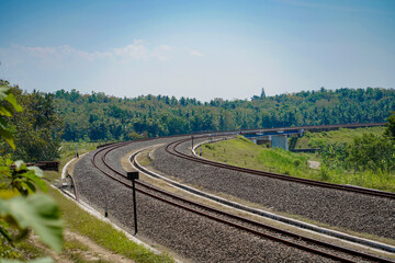 Fototapeta na wymiar 2-way train track with left and right views of dense forest during the day