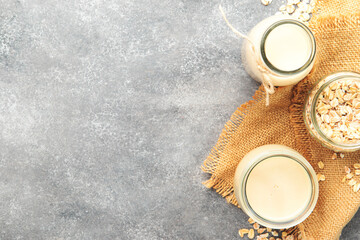 Obraz na płótnie Canvas Plant based oat flakes milk, non dairy vegan alternative drink in glass, top view, negative space