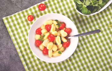 Homemade Italian gnocchi with tomato cherry on the table