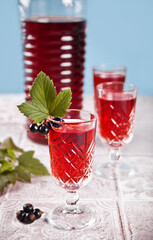 glasses of black currant brandy liqueur with ripe berries