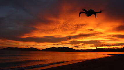 Fototapeta na wymiar 『ドローンのシルエット』オレンジ色の海とマジックアワーの夕日！