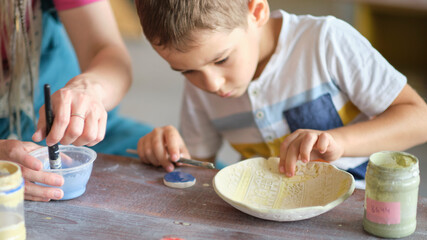 workshop for kids. Children learning how to use clay for making beautiful dishes. Workshop, master class.