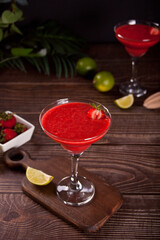 Cold strawberry margarita or daiquiri cocktail with lime and rum