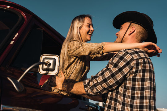 Happy couple embracing near retro car