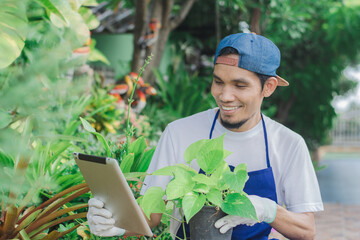 Happy man garden shop owner use tablet sale online small floral on internet shop