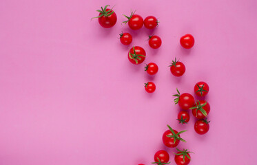Fresh red cherry tomatoes on a pink background. He was lying flat. Top view of a ripe juicy tomato on a pink background. Wallpaper with tomatoes. Vegetable texture. A place to copy