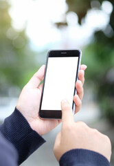 Cropped shot view of man hands holding smart phone with blank copy space screen for your text message or information content, female reading text message on cell telephone during in urban setting.
