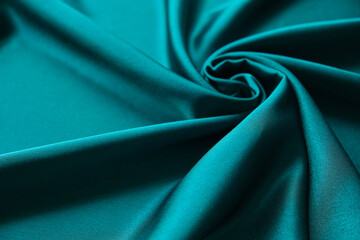 Blue silk drapery and upholstery fabric from the courtyard. Blue satin, silky fabric, wave, draperies. Beautiful textile backdrop. Close-up. Top view