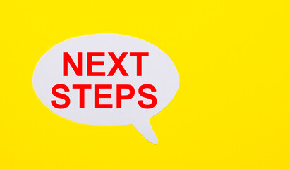 On a bright yellow background, white paper with the words NEXT STEPS