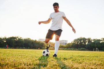 Forest on background. Young soccer player have training on the sportive field