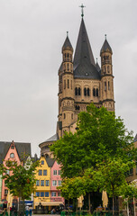 Fototapeta na wymiar Picturesque view of Cologne's Old Town, including the soaring crossing tower of the Great Saint Martin Church. The quadrangular tower, a landmark, has at each four corners another smaller tower.