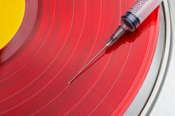 bright colored vinyl records spinning with a medical needle, music addiction concept