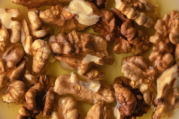 Food close-up: walnuts with honey in a saucer