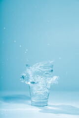 Ice cubes splashing into glass of water, isolated on white