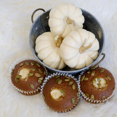 A peaceful setting of cupcakes and gourds on a bedroom serving table.