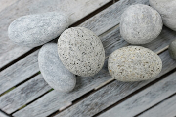 Beach stones sit on a weathered wood table