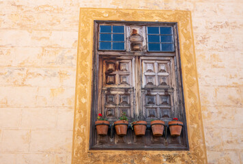 Old wooden window with flowers pots