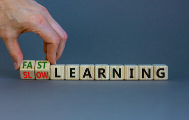 Fast or slow learning symbol. Businessman turns cubes, changes words 'slow learning' to 'fast learning'. Beautiful grey background. Business, education and fast or slow learning concept. Copy space.